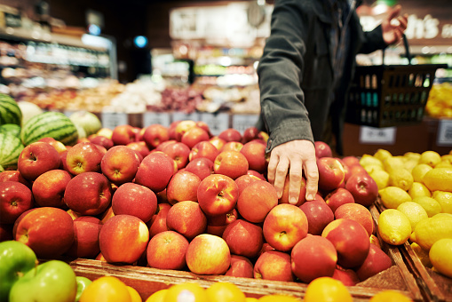 Cropped shot of a man shopping for apples in a grocery store