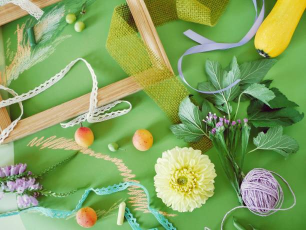 istock Decorative seasonal composition of fruit, decor, greenery and a wooden empty frame on green tinted paper 1137403475