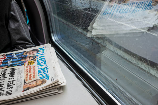 A passenger's newspaper's and its reflections in the Train, traveling between Brussels and Leuven, Belgium.