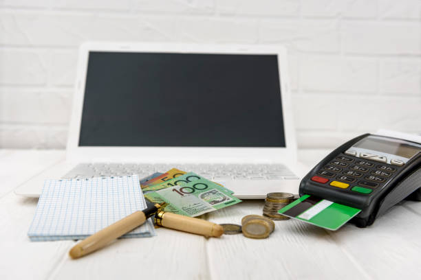istock Australian dollar with terminal, laptop and notepad 1137406337