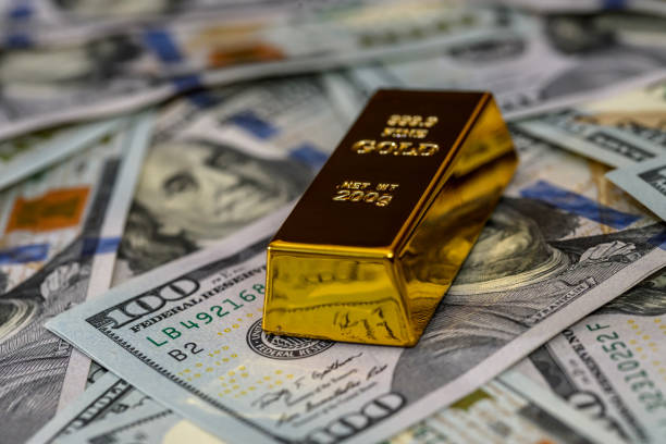 istock One gold bullion with dollar banknotes closeup 1137406931