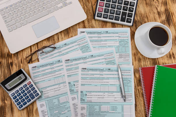 istock 1040 form with coffee, calculator and laptop 1137408097