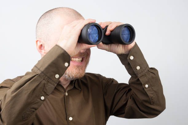 istock Bearded man with binoculars in his hands looking happily into the distance 1137408162