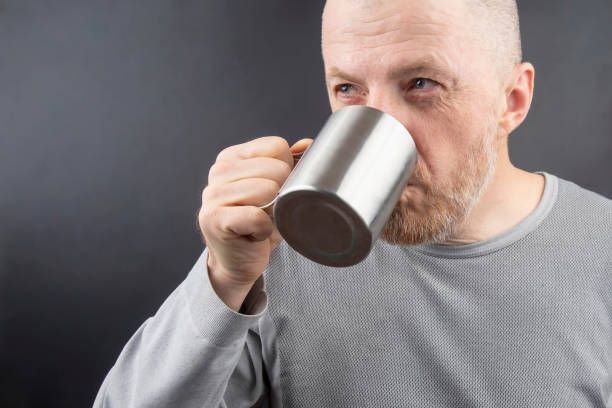istock Bearded man drinking tea from a metal mug 1137408218
