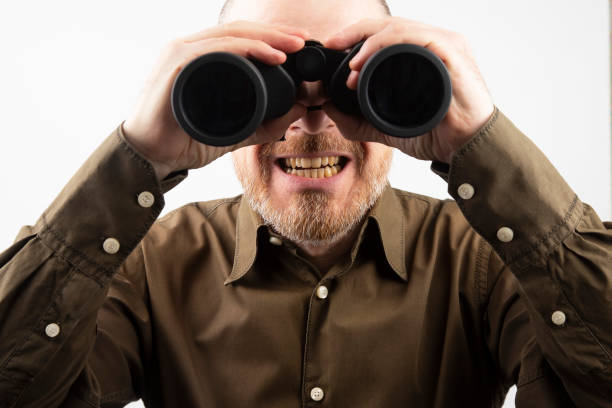 istock Bearded man looking through binoculars into the distance 1137408350