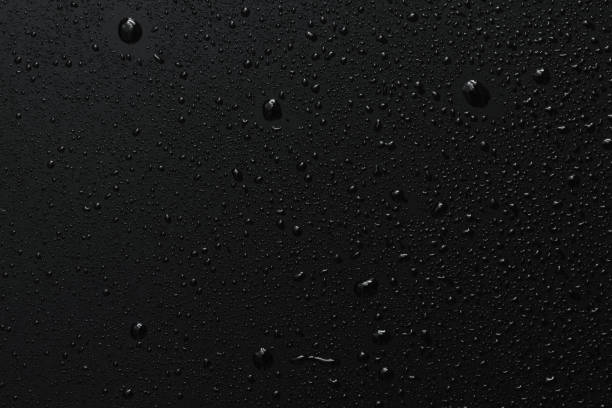 Black surface with clear water drops, background Close-up of raindrops on black rough surface, dark background black glass surface stock pictures, royalty-free photos & images