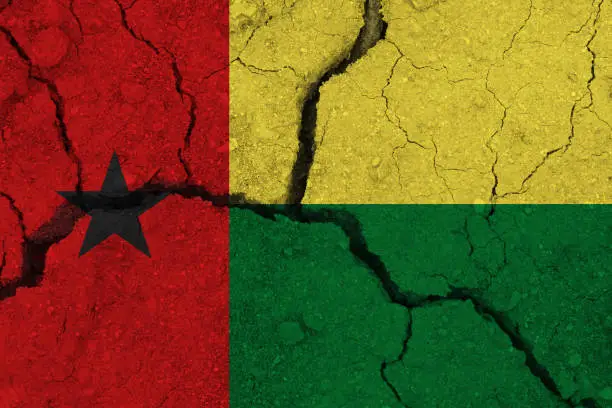 Photo of Guinea-Bissau flag on the cracked earth
