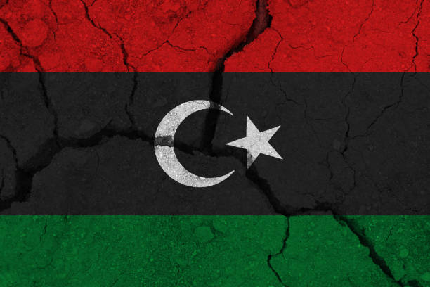 bandera de libia en la tierra agrietada - libyan flag fotografías e imágenes de stock