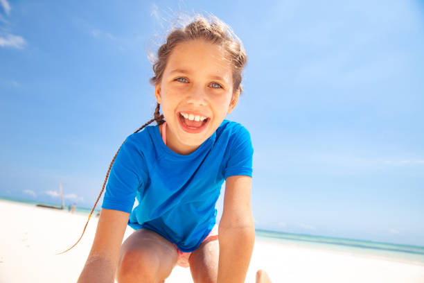 Happy Little Girl playing on White Sandy Beach