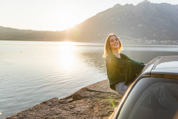 istock Happy young woman smiling from car window 1137425517