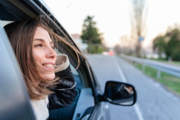 istock Young woman inside a car with the window open looking away 1137426714