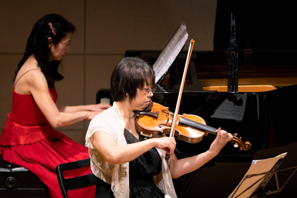 istock Violinist and pianst playing at classical music concert 1137428474