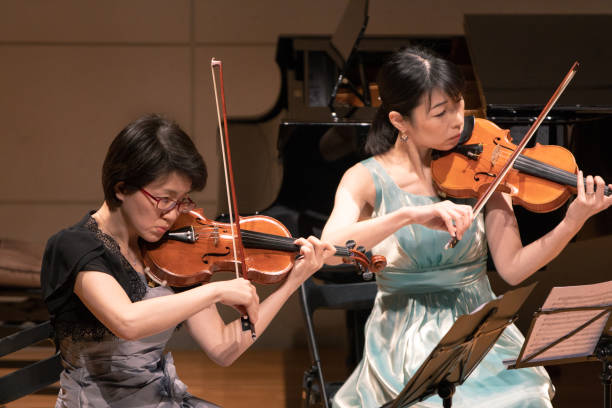 istock Female violinists playing at classical music concert 1137429000