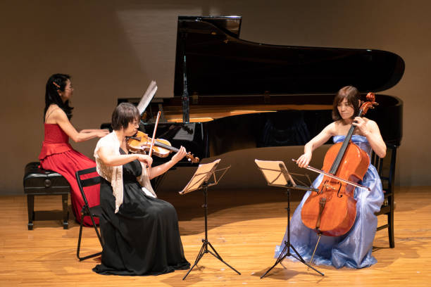 istock Three musicians playing violin and piano at classical music concert 1137429572