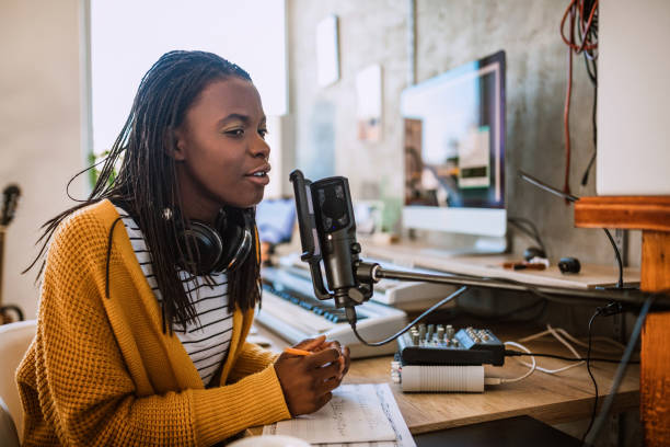 Female host on radio station Cheerful African woman working on radio station, talking on microphone in talk show podcasting photos stock pictures, royalty-free photos & images