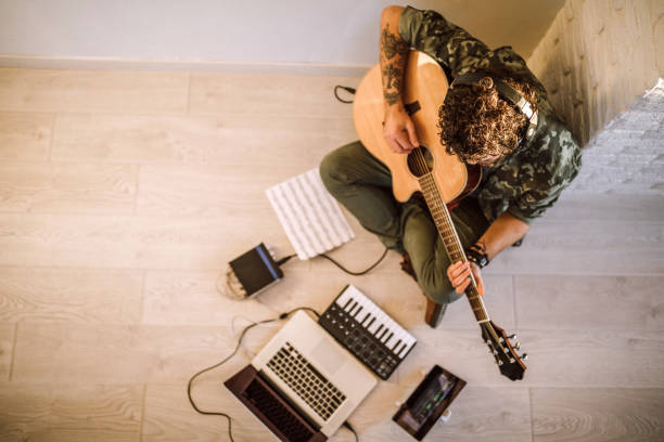 istock Man playing guitar at home 1137437971
