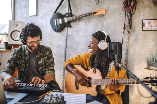 Music makes us truly happy Happy, young couple smiling lively while recording music at home producer stock pictures, royalty-free photos & images