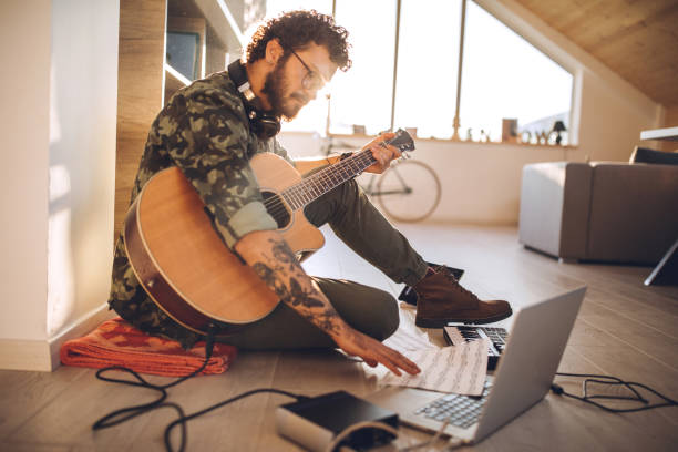 istock Hipster man practicing acoustic guitar at home 1137438516