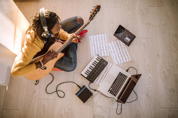 istock Woman playing guitar at home 1137439044