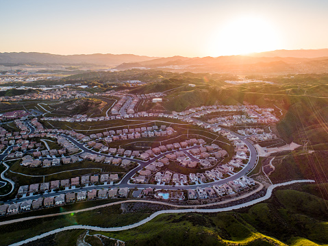 Aerial of tract housing and American suburban development in Southern California at sunset.