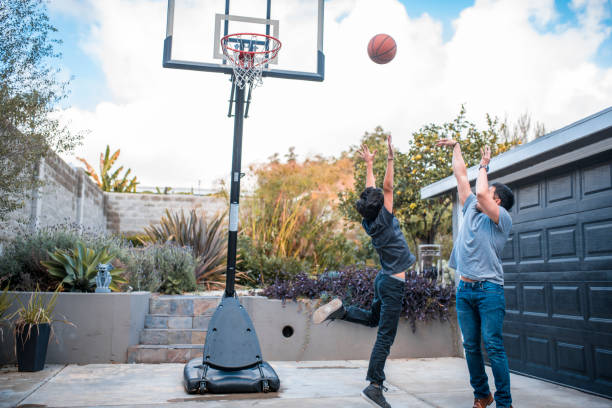 vater und sohn mit waffen erhoben beim basketball - basketball basketball hoop california southern california stock-fotos und bilder