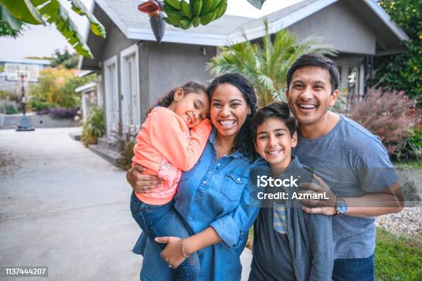 Portrait Of Happy Family Against House Stock Photo - Download Image Now - Family, Latin American and Hispanic Ethnicity, Multiracial Group