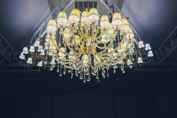 istock Big pendant layers lamps pattern on classic ceiling inside the hall in the night. 1137444555