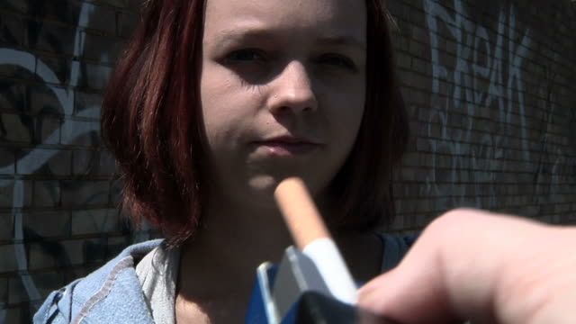 Teen reluctantly takes cigarette