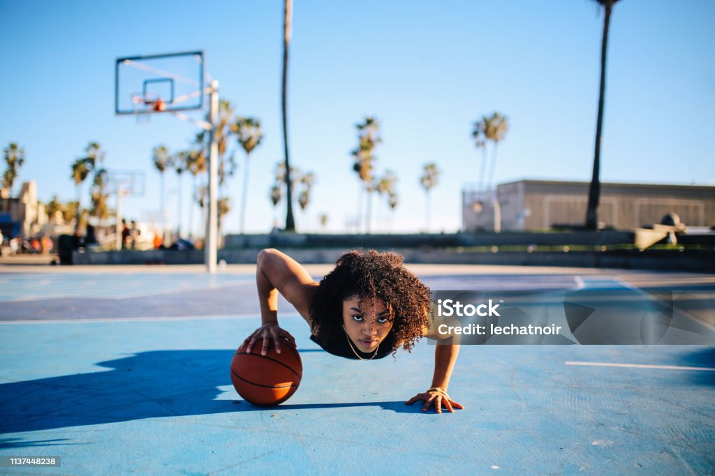 一個年輕女性做一隻手俯臥撐的低角度肖像 - 免版稅籃球 - 團體運動圖庫照片