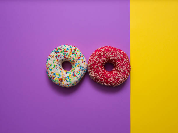 istock Sweet donut on purple and yellow background 1137454103