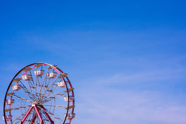 rueda de la fortuna contra el cielo azul claro - ferris wheel carnival amusement park wheel fotografías e imágenes de stock