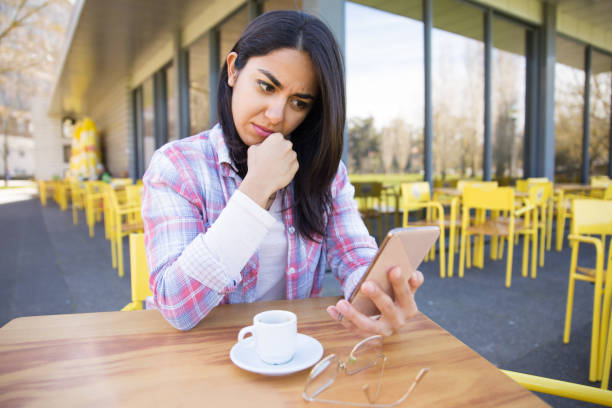 istock Worried woman using smartphone and drinking coffee in cafe 1137462969