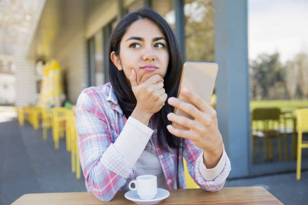 istock Tired bored girl using smartphone over cup of coffee 1137463007