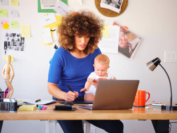 istock Working Mother Balancing Baby and Design Work 1137467746