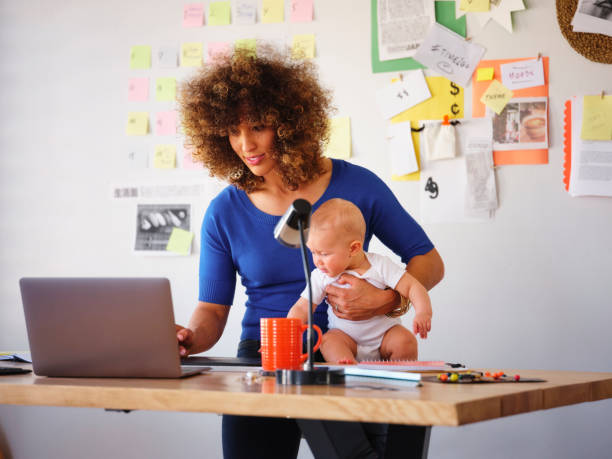istock Working Mother Balancing Baby and Design Work 1137467850