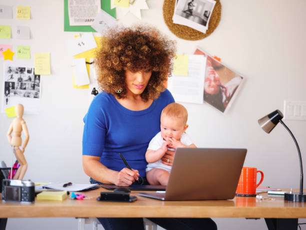 istock Working Mother Balancing Baby and Design Work 1137467976