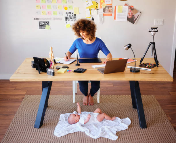istock Working Mother Balancing Baby and Design Work 1137467977