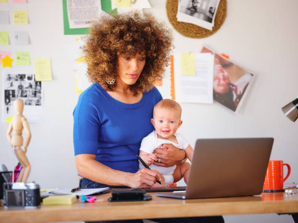 istock Working Mother Balancing Baby and Design Work 1137468019