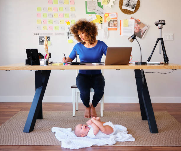 istock Working Mother Balancing Baby and Design Work 1137468060