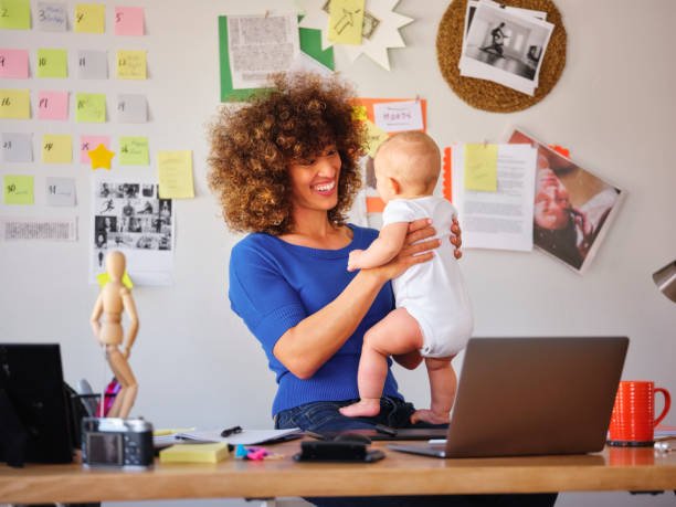 istock Working Mother Balancing Baby and Design Work 1137468080