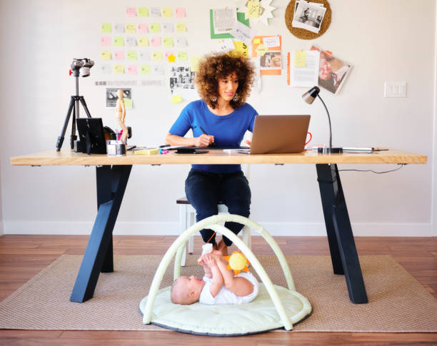 istock Working Mother Balancing Baby and Design Work 1137468084