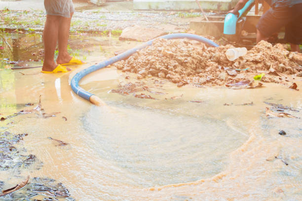 istock broken pipe in hole with water motion at roadside and plumber working repair 1137468825