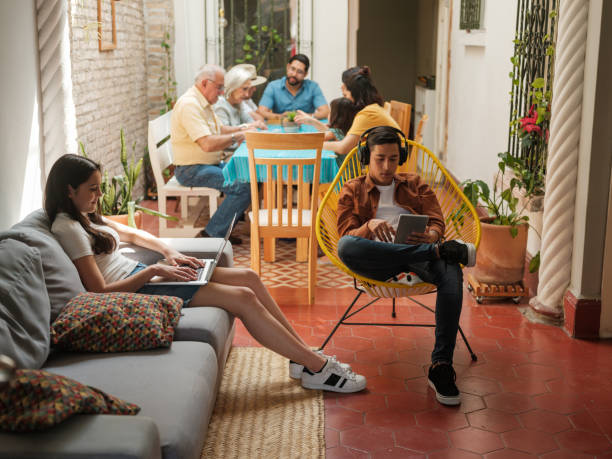 modern mexican family reunion - grandparent using computer laptop dining table imagens e fotografias de stock