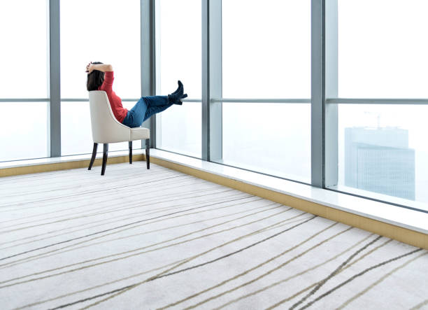 A man leaning against a pillar in an empty office, sunrise