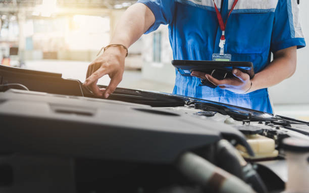 auto mécanicien utilise la tablette pour vérifier. - mettre en échec photos et images de collection