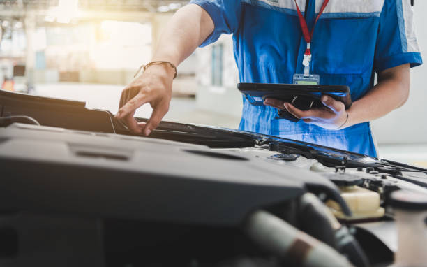 Auto mechanic uses the tablet to check. Auto mechanic are checking the condition of the car according to the month. The technician uses the tablet to check. quality control photos stock pictures, royalty-free photos & images