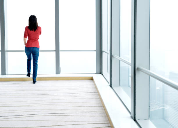 istock Woman using phone in front of window 1137477007