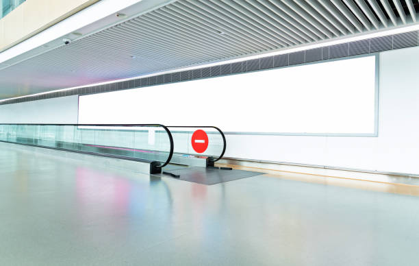 Blank billboard on the wall of pedestrian walkway Blank billboard on the wall of pedestrian walkway. airport travelator stock pictures, royalty-free photos & images