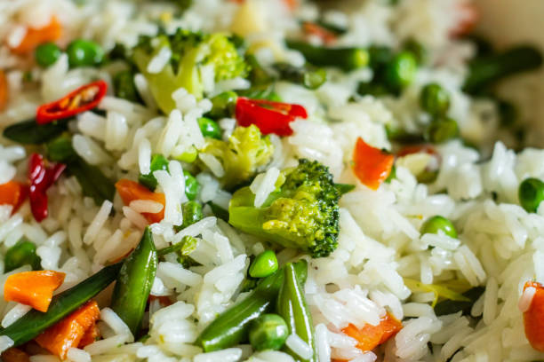 Large white dish with brown rice, cassava and pod. Selective focus.