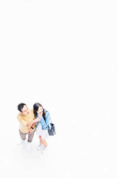 istock Asian Couple Walking Through a Brightly Lit Shopping Mall 1137484344